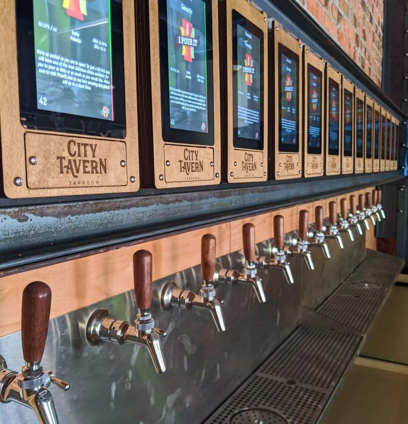 City Tavern History Self-serve tap wall at City Tavern with digital beer menus and wooden-handled taps