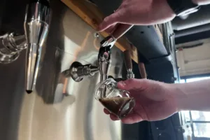 guest at city tavern pouring beer in the self-serve tap wall